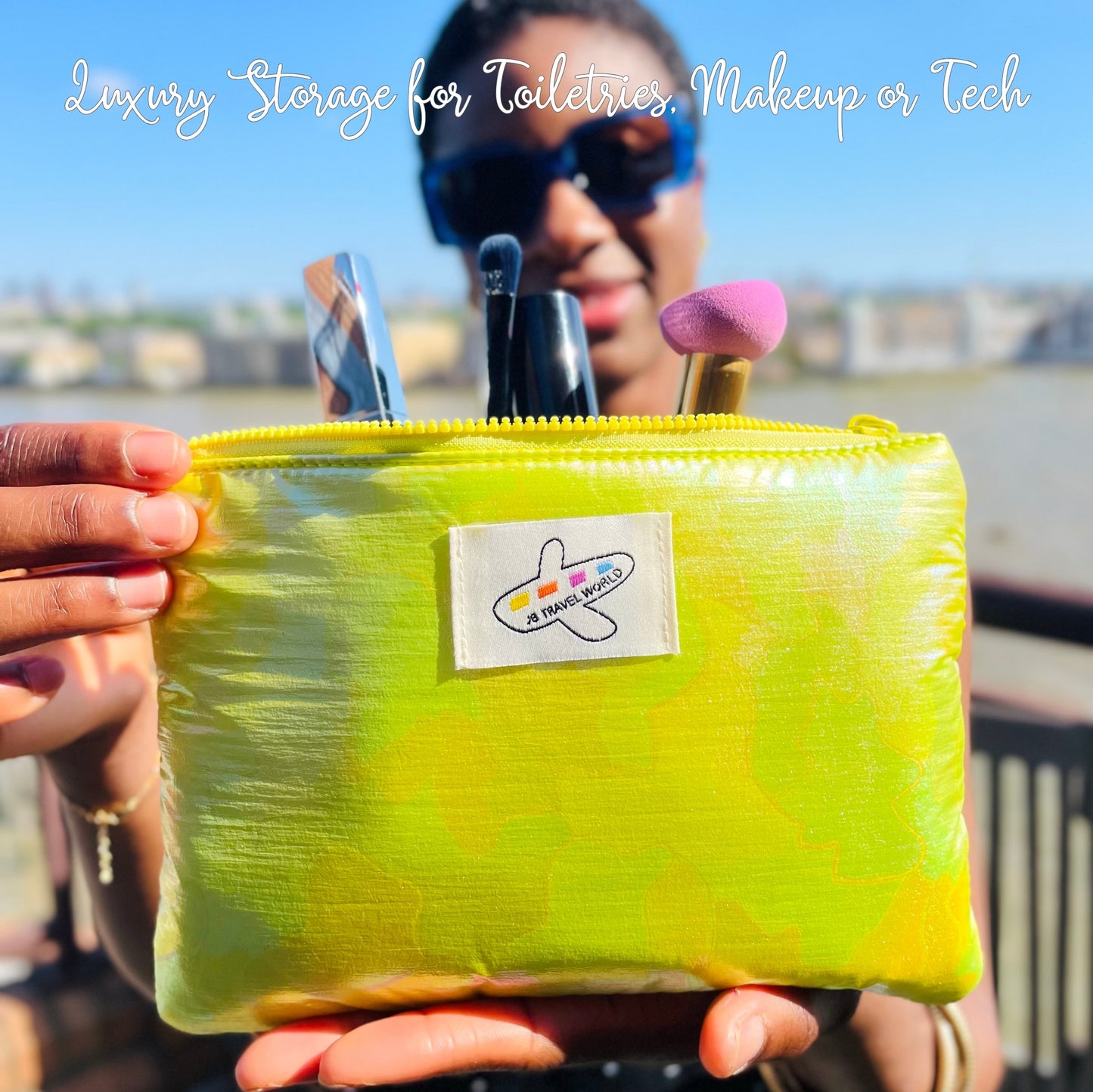 Person holding a green iridescent cosmetic bag with makeup brushes and tools, outdoors.