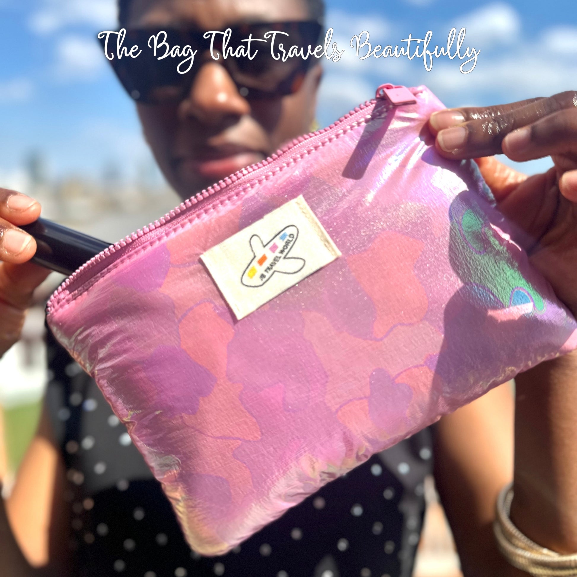 Person holding pink shimmer travel makeup bag open with cosmetics visible – JB Travel World